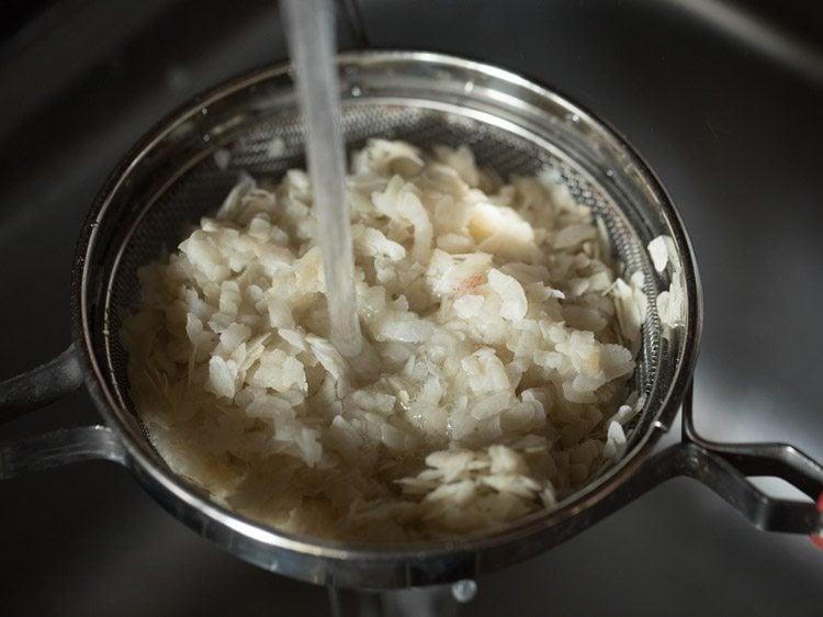 rinsing poha under running water. 