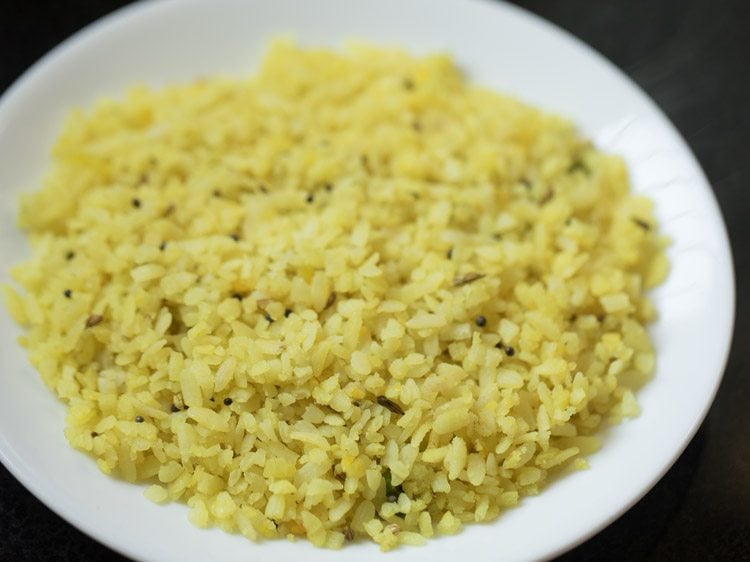 hot poha added to a plate. 