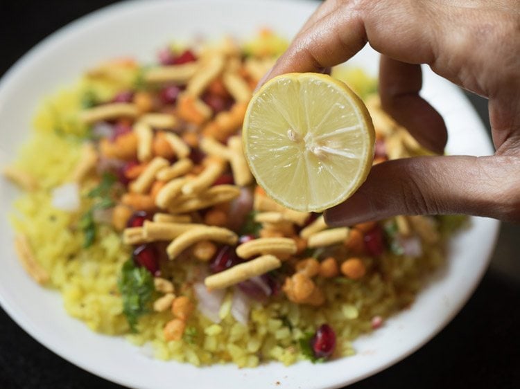 squeezing lemon on top of poha. 