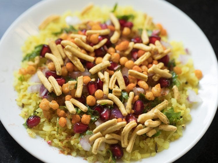 indori poha served on a white plate. 