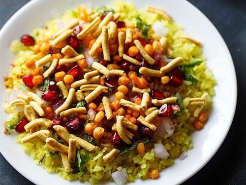 indori poha served on a white plate. 