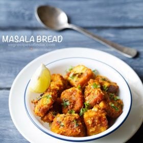 masala bread garnished with chopped coriander leaves and served in a blue rimmed bowl with a lemon wedge and a spoon kept in the background and text layover.