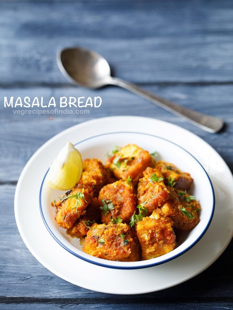 masala bread garnished with chopped coriander leaves and served in a blue rimmed bowl with a lemon wedge and a spoon kept in the background and text layover.