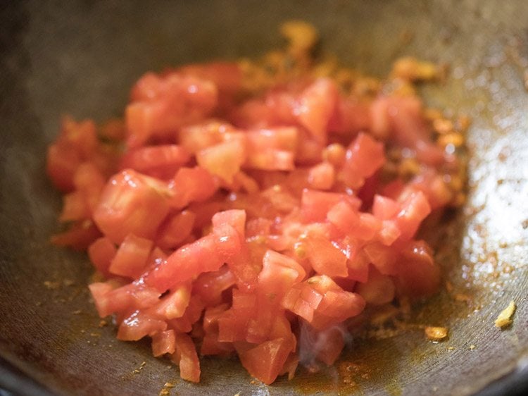 finely chopped tomatoes added to pan for making bread masala. 