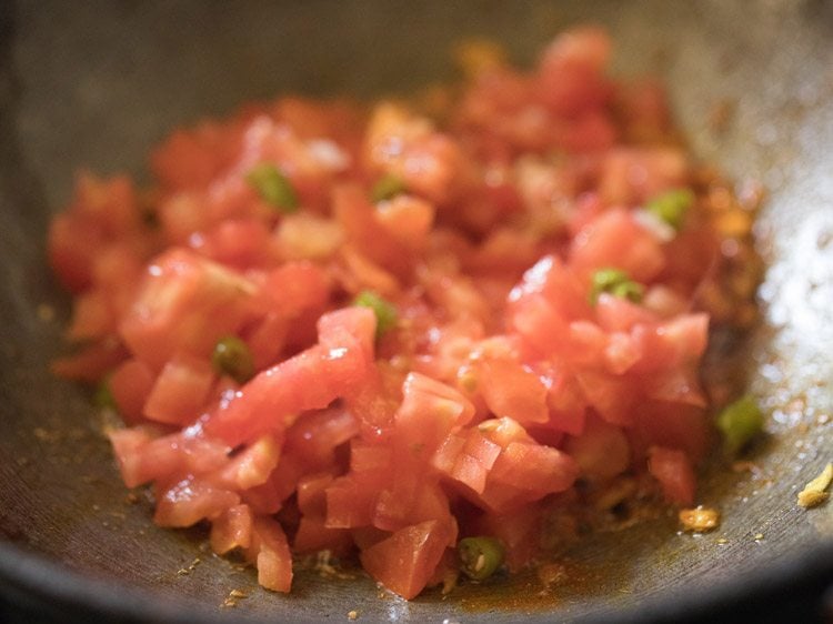 chopped green chili added to tomatoes for making masala bread. 