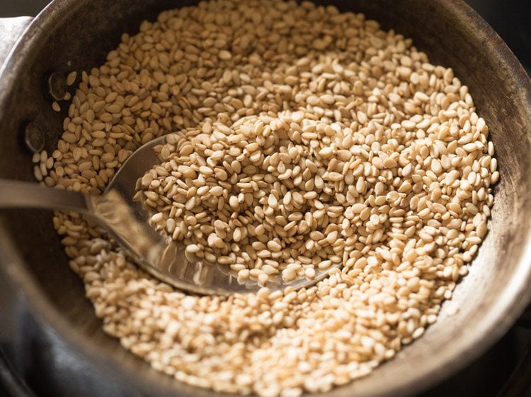 stirring and roasting sesame seeds. 