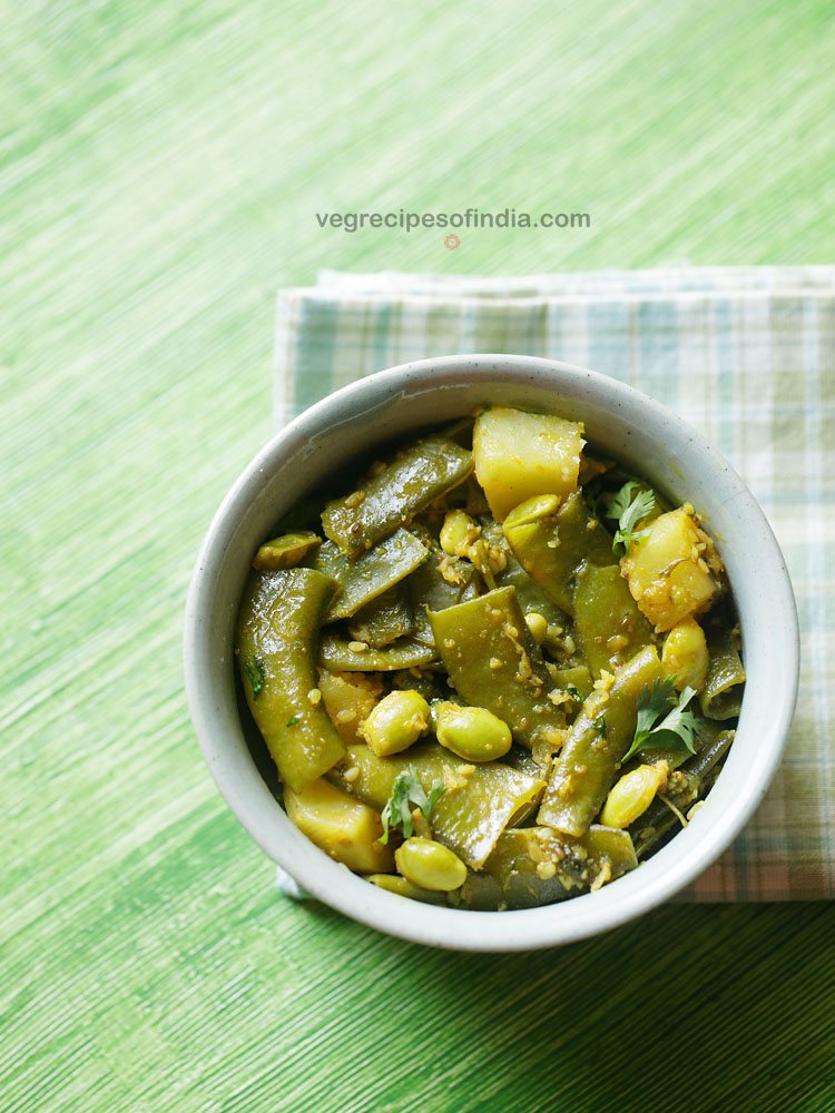 aloo sem ki sabji garnished with coriander leaves and served in a bowl. 