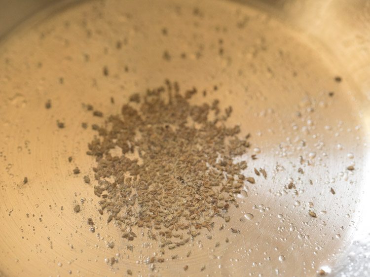 carom seeds spluttering in hot oil in pan for valor papdi nu shaak. 