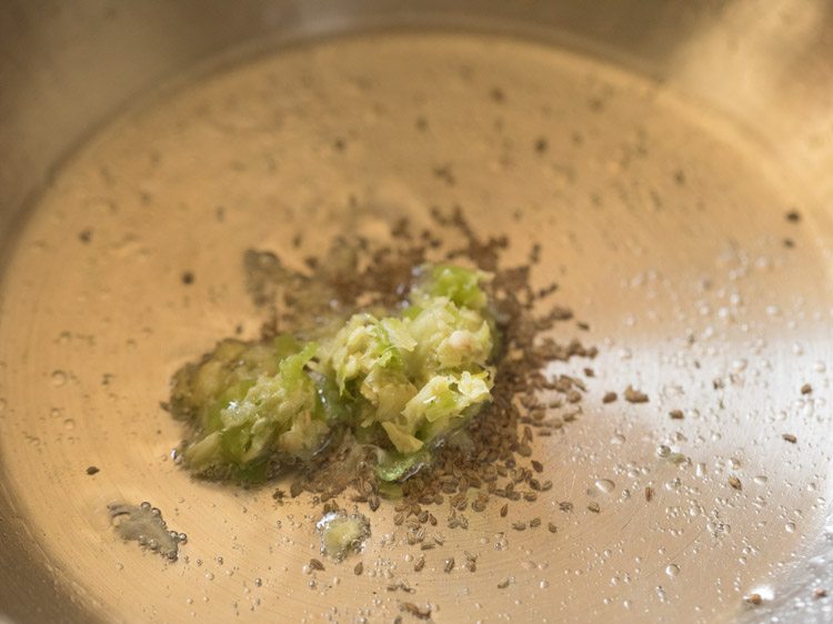 prepared ginger-garlic-green chili paste added in pan for valor papdi nu shaak. 