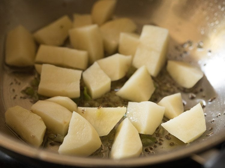 chopped potatoes added to pan for valor papdi nu shaak. 