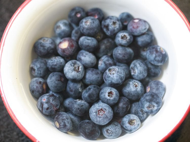 blueberries in a red rimmed white  bowl for making blueberry smoothie recipe