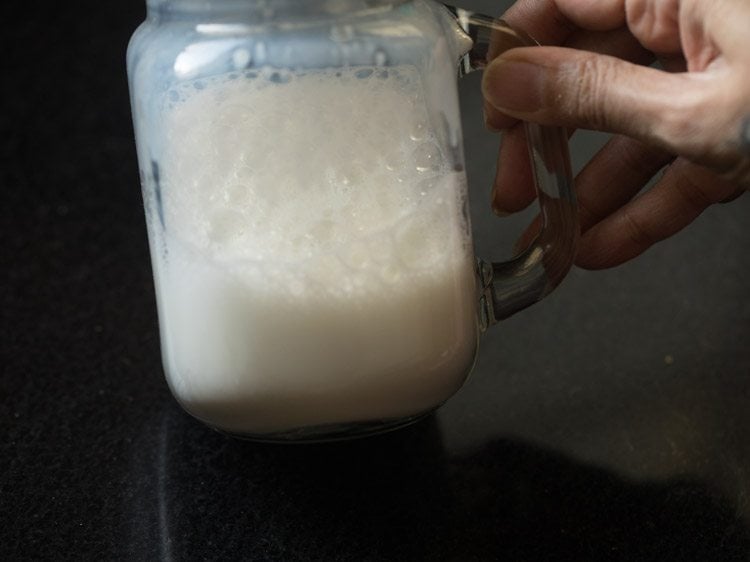 shaking the heated milk for making cappuccino recipe with instant coffee.