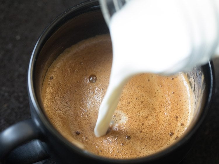 adding the rest of the milk to the cafe-style coffee.