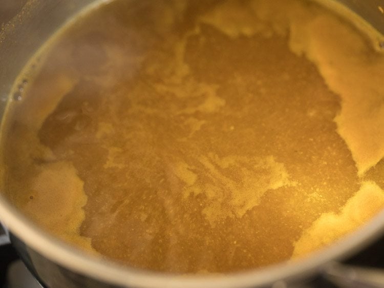 boiling tamarind mixture for coconut milk rasam.