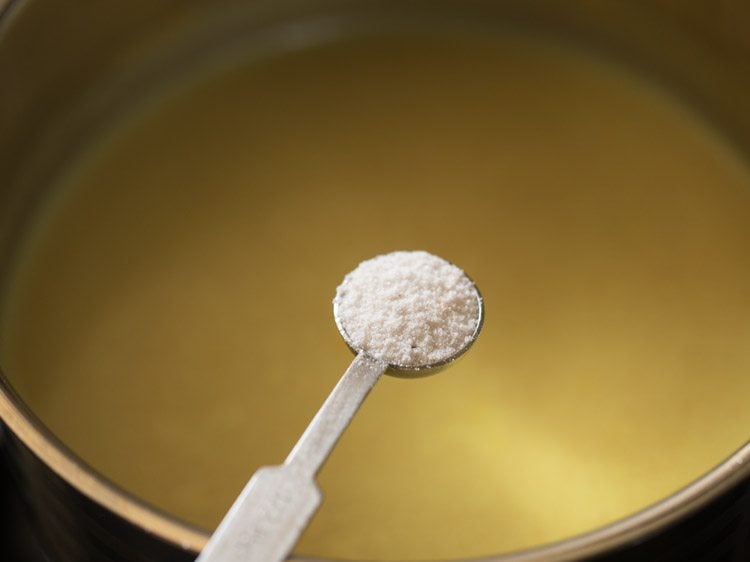 adding salt to coconut milk-tamarind mixture for thengai paal rasam.