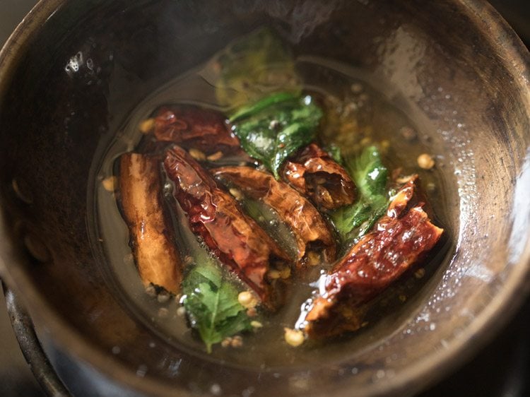 frying ingredients for tempering thengai paal rasam.