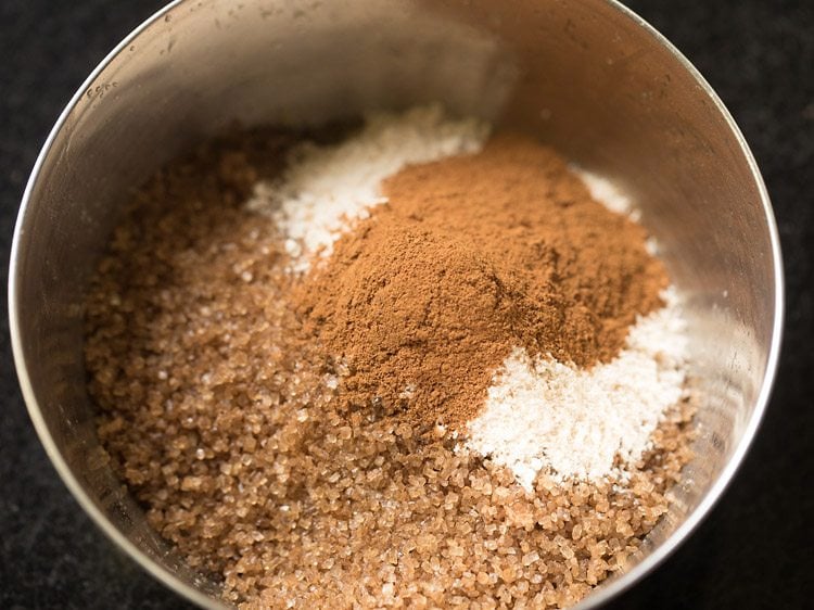 adding brown sugar, atta, and cinnamon powder to butter and nuts for making streusel.
