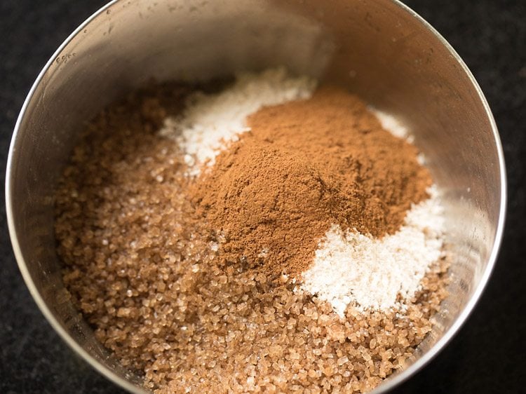 adding brown sugar, atta, and cinnamon powder to butter and nuts for making streusel.