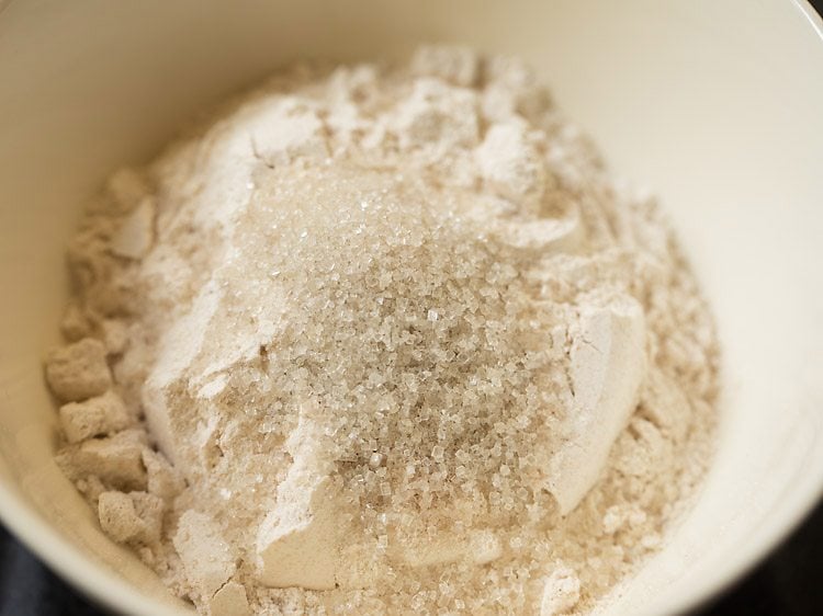 Closeup shot of whole wheat flour and sugar in mixing bowl.