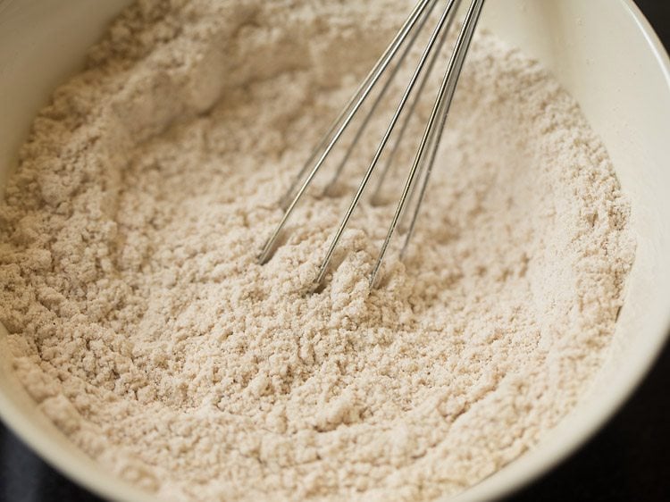 Whisk mixing dry ingredients for eggless waffle recipe.