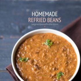 refried beans garnished with coriander leaves and served in a white bowl with text layovers.