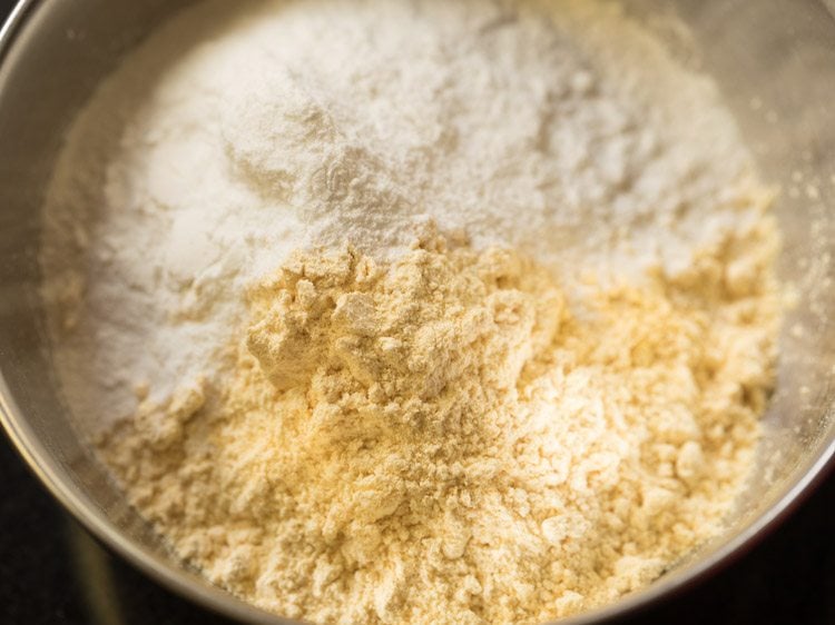 gram flour and rice flour added to a bowl to make batter for chilli bajji.