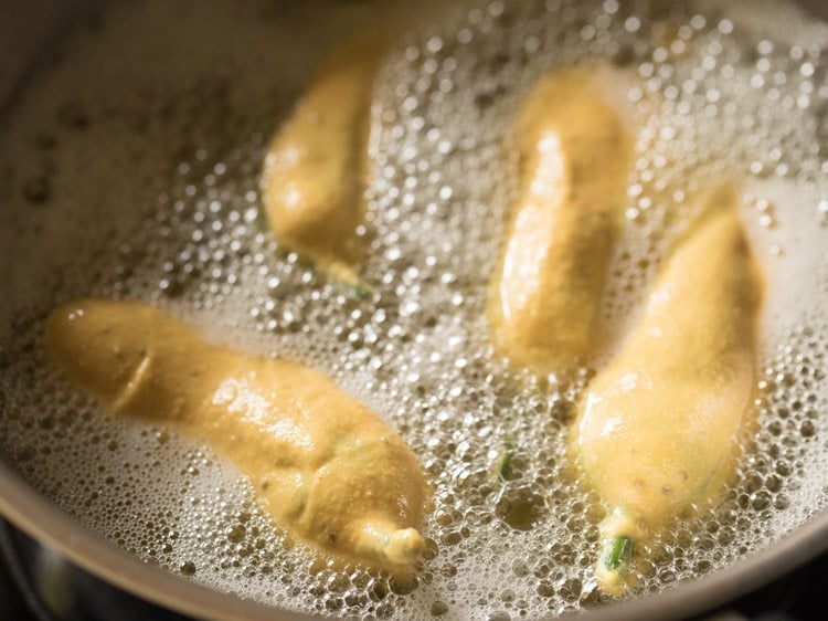 frying stuffed green chilies in hot oil. 