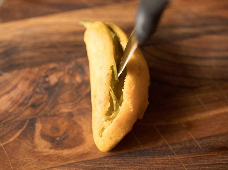 cutting fried mirchi bajji from one side. 