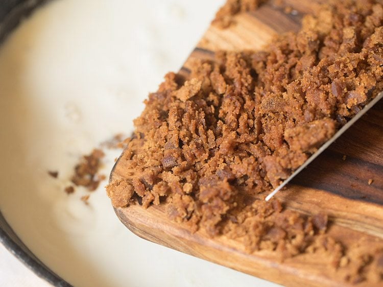 adding chopped palm jaggery to the reduced milk. 