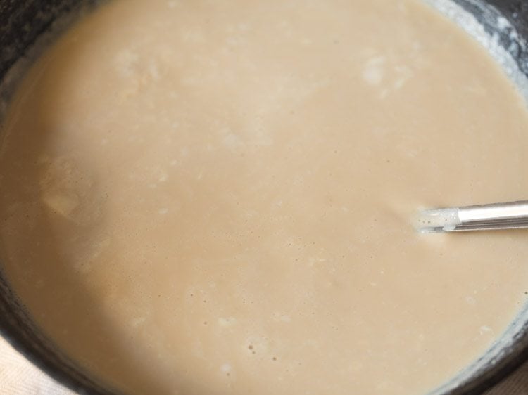 mixing palm jaggery well in the milk. 