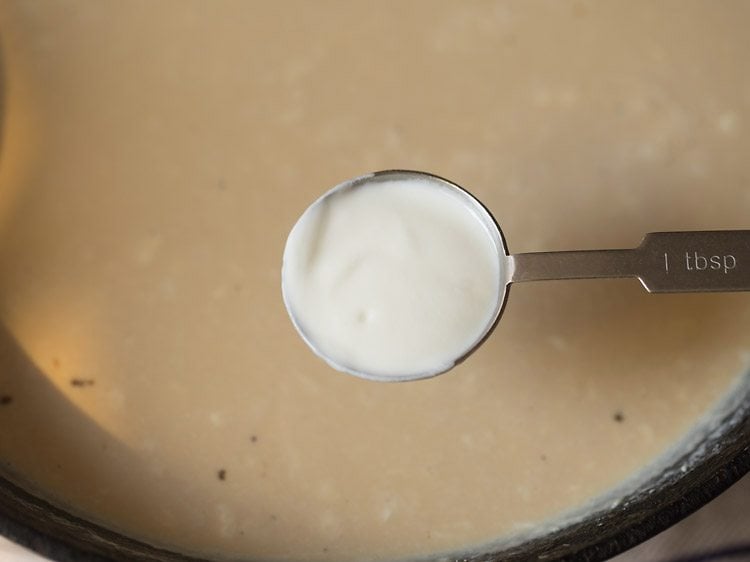 adding curd to the milk-jaggery mixture. 