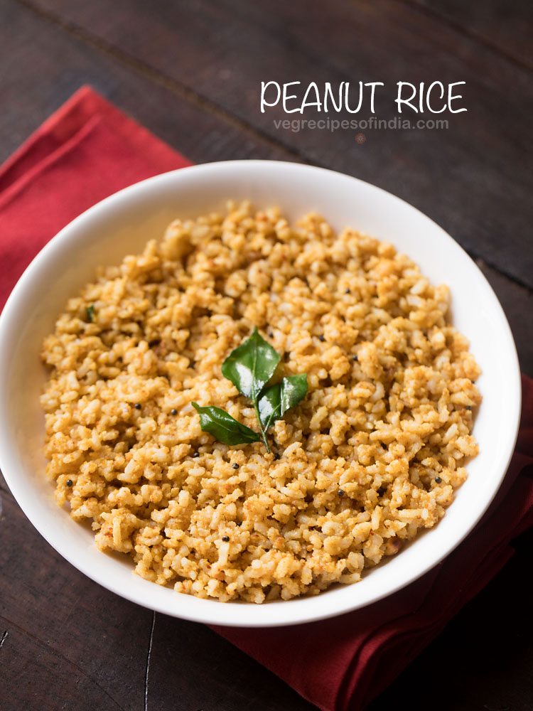 peanut rice garnished with a fried curry leaf sprig and served in a white bowl.