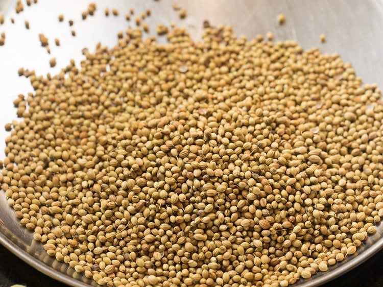 roasted coriander seeds on a steel plate.