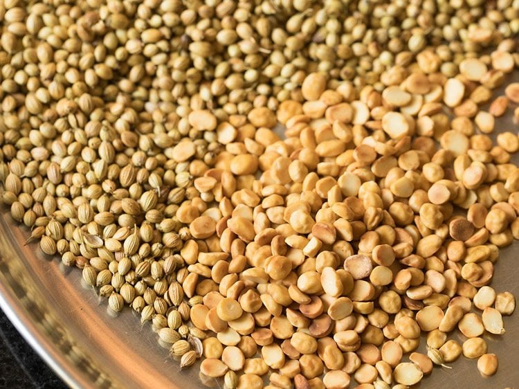 roasted coriander seeds and chana dal on a steel plate. 