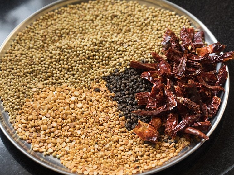 roasted spices and lentils kept on a large steel plate. 