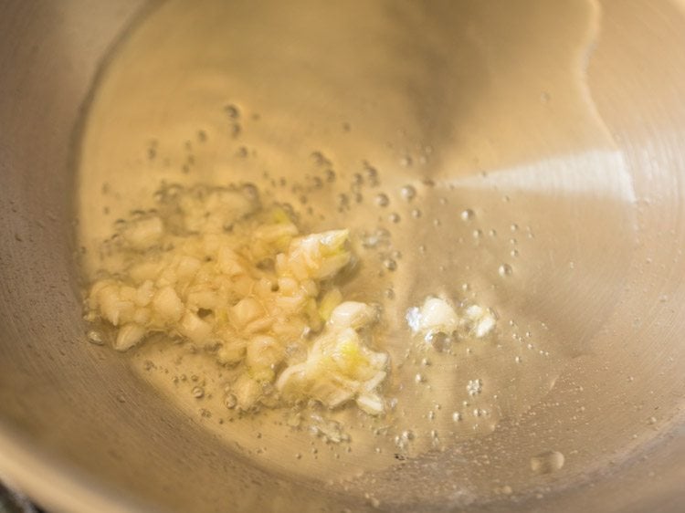 finely chopped garlic added to hot olive oil in pan for refried beans recipe. 
