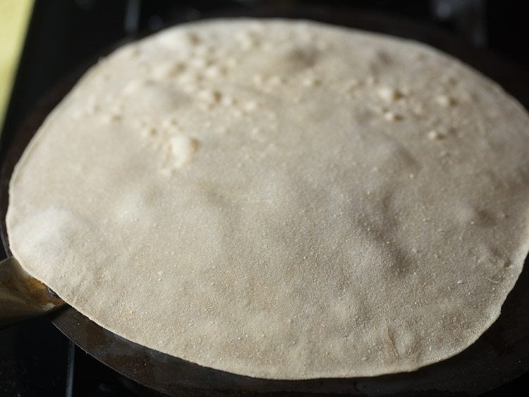 rolled rumali roti placed on inverted tawa. 