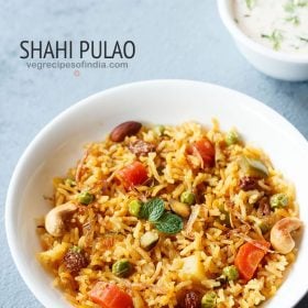 shahi pulao garnished with mint leaves, fried nuts, dry fruits, onions and served in a white bowl with a small bowl of raita kept on the top right side and text layovers.