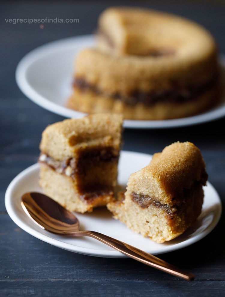 2 slices of streusel sour cream coffee cake on a white plate with a rose gold spoon.