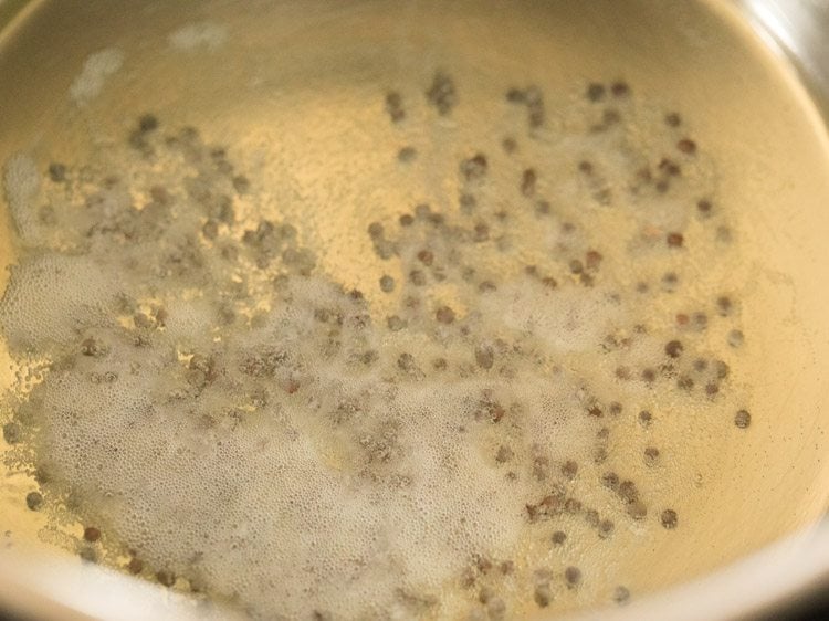 mustard seeds crackling in hot sesame oil for vatha kuzhambu. 