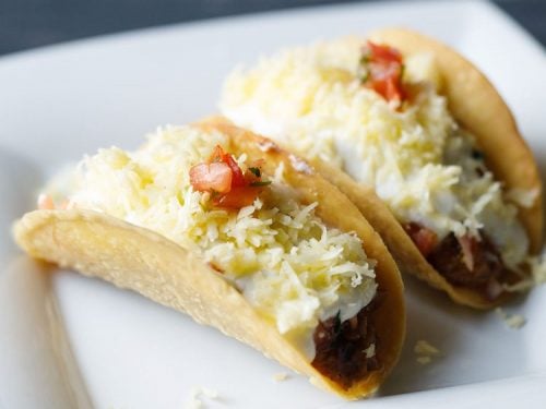 vegetarian tacos on a square white plate.