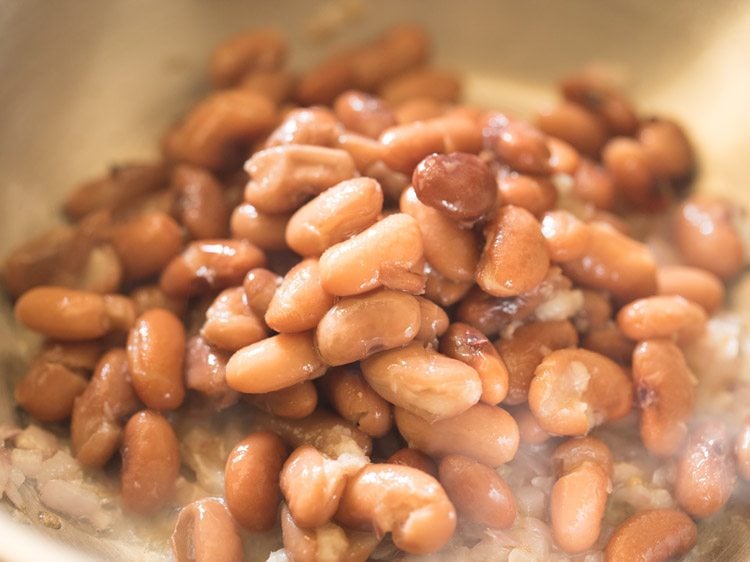 cooked kidney beans added to pan. 