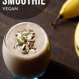 banana smoothie filled in a stout glass topped with toasted seeds