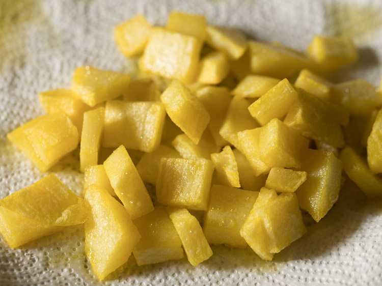 fried potato cubes on kitchen paper towels. 