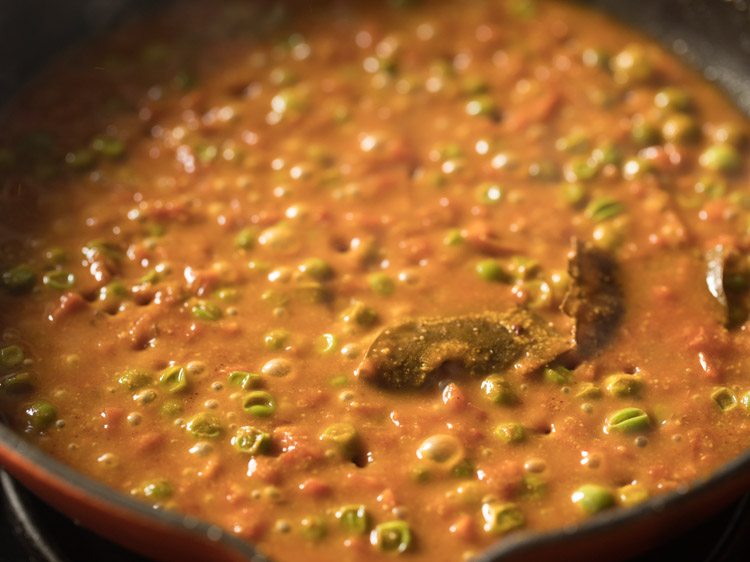simmering curry till the green peas are cooked well. 