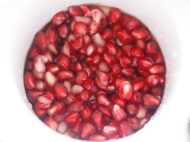pomegranate arils in the base of a juice extractor.