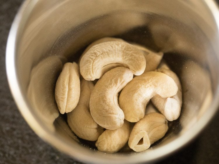 adding cashewnuts in a mortar for making praline 