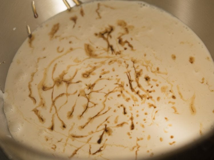 chilled whipping cream and vanilla extract in a stand mixer bowl 