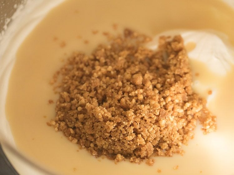 adding crushed butterscotch praline to the whipped cream-condensed milk mixture.