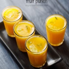 a serving tray filled with garnished glasses of fruit punch.